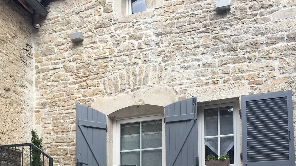 La façade en pierre du gîte Le Murger et ses volets gris-bleu